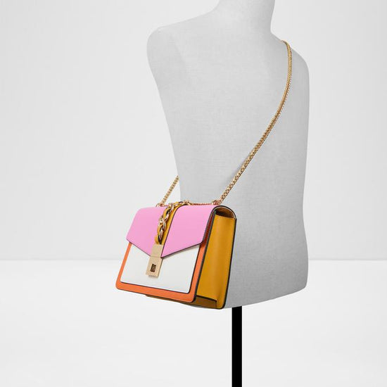 Pink and white handbag with gold chain on a light gray background